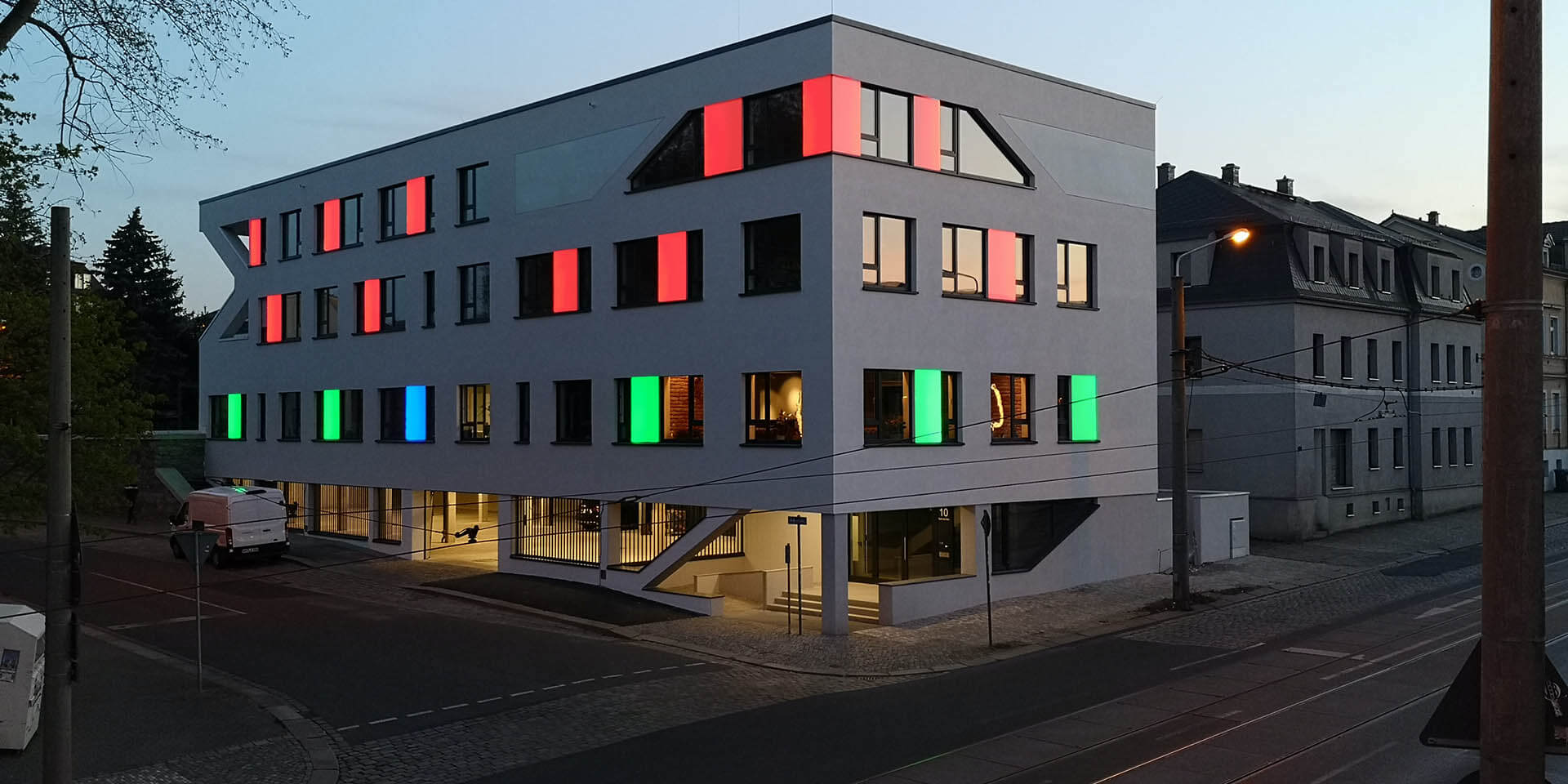 Partielle LED Fassadenbeleuchtung in verschiedenen Farben (rot, grün, blau); led facade lighting: red, green and blue coloured led-panels beside the windows (colour change)