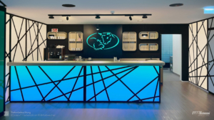 LED-Bar-Theke: Blaue Thekenbeleuchtung und türkises "Bulle und Bär"-Symbol im Hintergrund