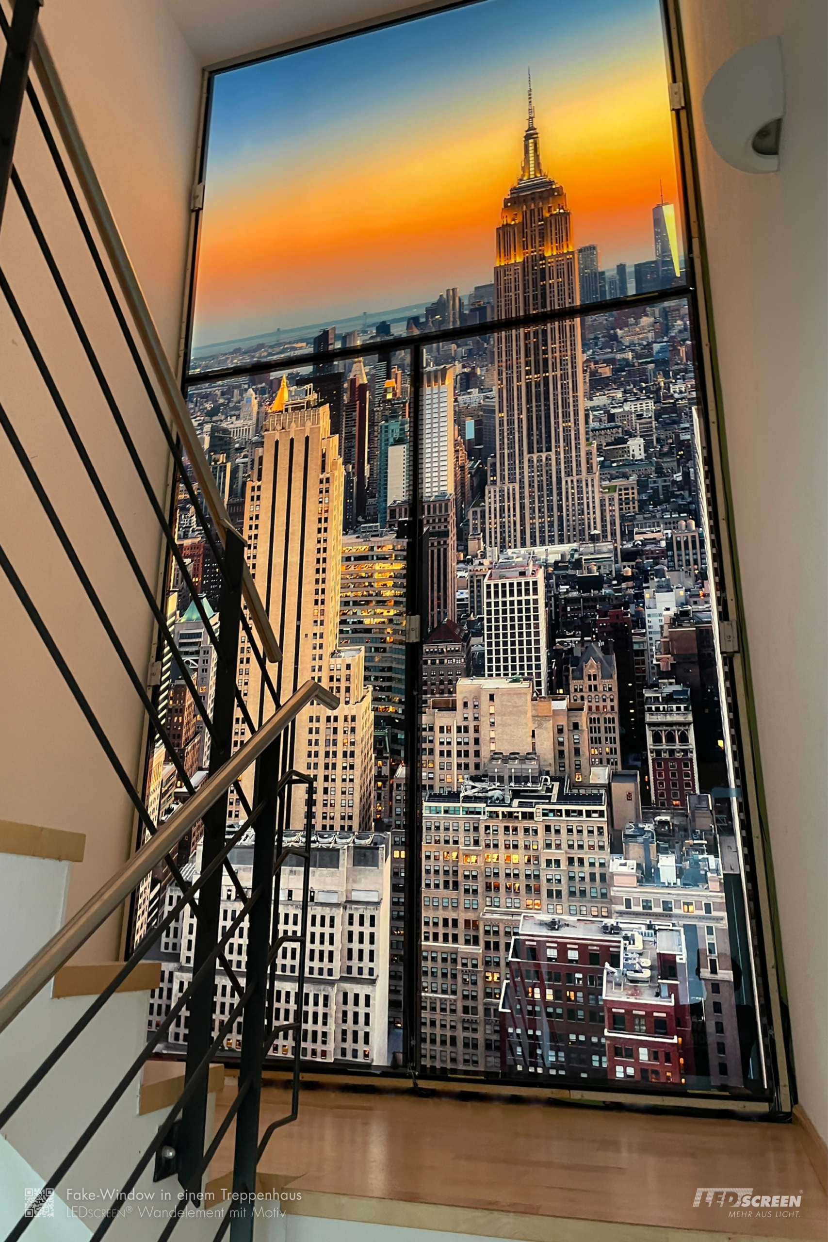 bodenlanges, dreigeteiltes künstliches Fenster aus Tageslicht-Panels mit Blick auf das Empire State Building in einem Treppenhaus.
