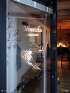 Outdoor-LED-Panel mit Logo als Isolierglas-Tür eines kroatischen Restaurants.